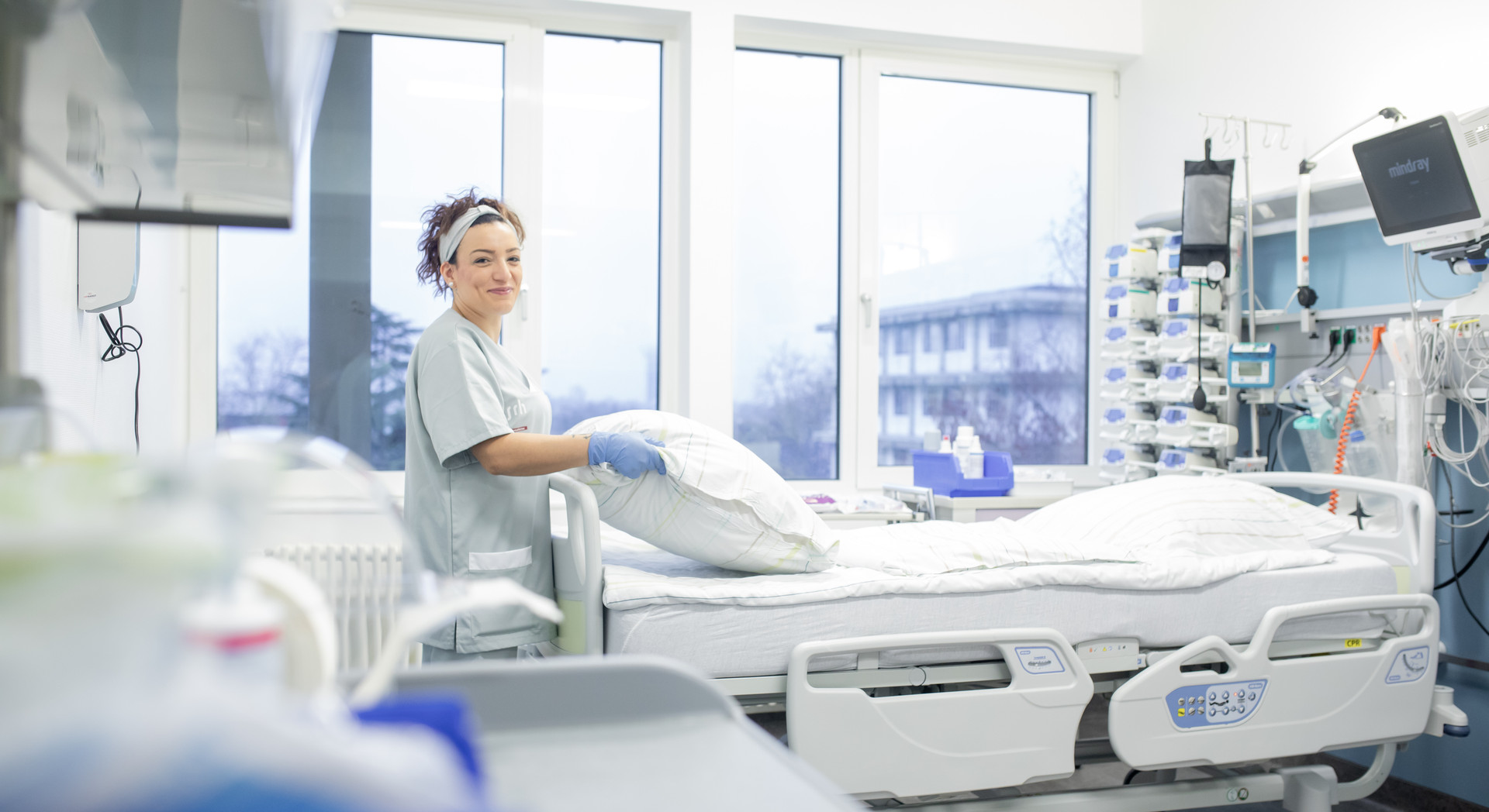 Reinigungskraft im Krankenhaus beim Betten machen