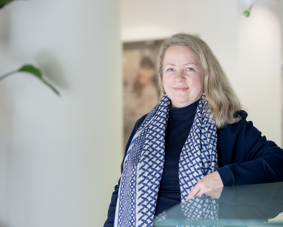Lächelnde blonde Frau in blauer Kleidung